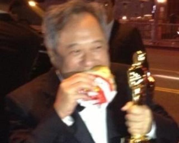 Ang Lee come lanche na rua com estatueta do Oscar na mão