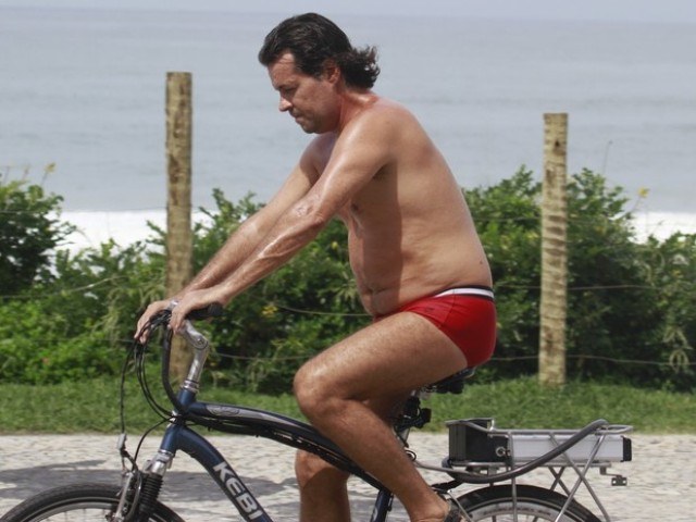 Felipe Camargo pedala de sunga pela orla carioca e exibe quilinhos a mais
