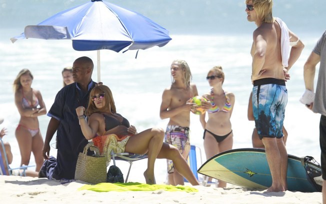 Fernanda Souza grava de biquíni e peruca loira com Marcelo Serrado na praia