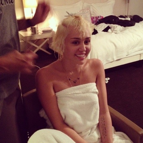 Miley Cyrus posa só de toalha enquanto muda o visual