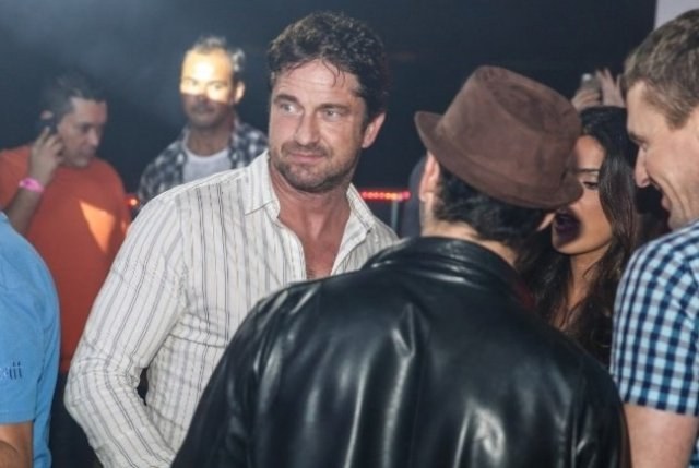 Gerard Butler se aproxima de modelo brasileira durante festa