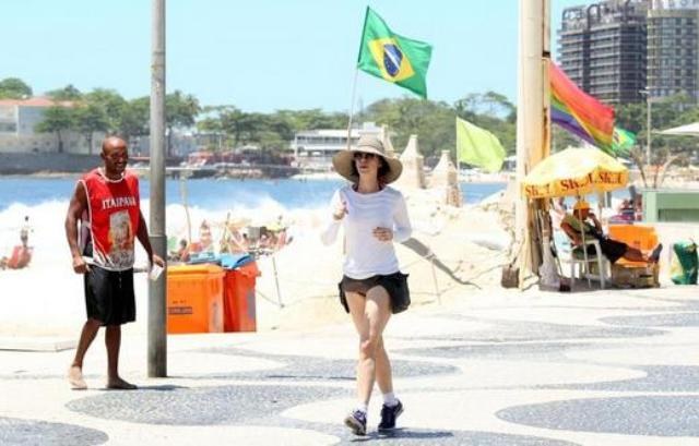 Mesmo com chapéu gigante, Fernanda Torres é reconhecida durante corrida na rua