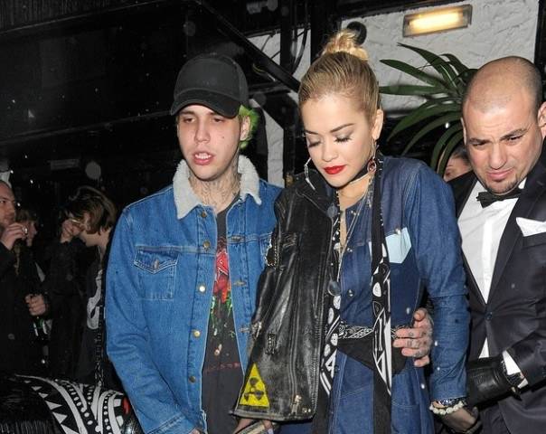 Rita Ora é amparada por namorado e segurança ao deixar boate