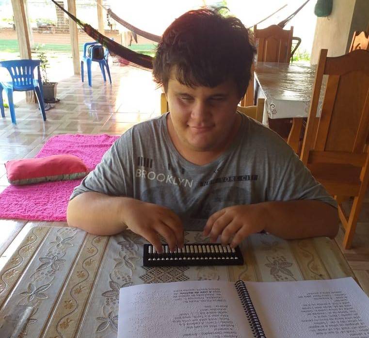 Vencendo as limitações físicas e as restrições da pandemia, aluno cego estuda em casa com texto em braile, em Cerejeiras