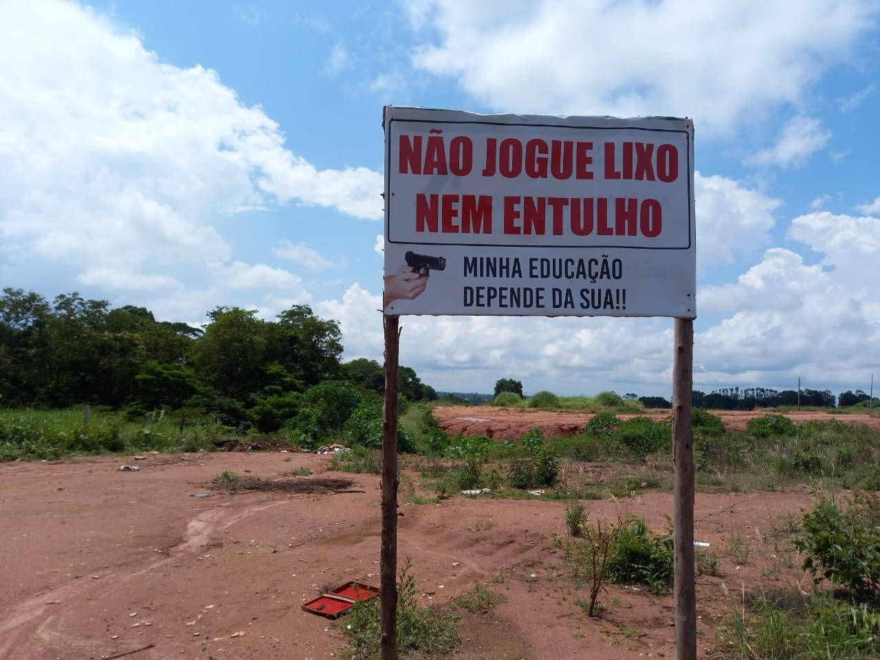 Cansado de recolher até cachorro morto jogado em terreno, proprietário instala placa com aviso e desenho de arma em punho em Cerejeiras