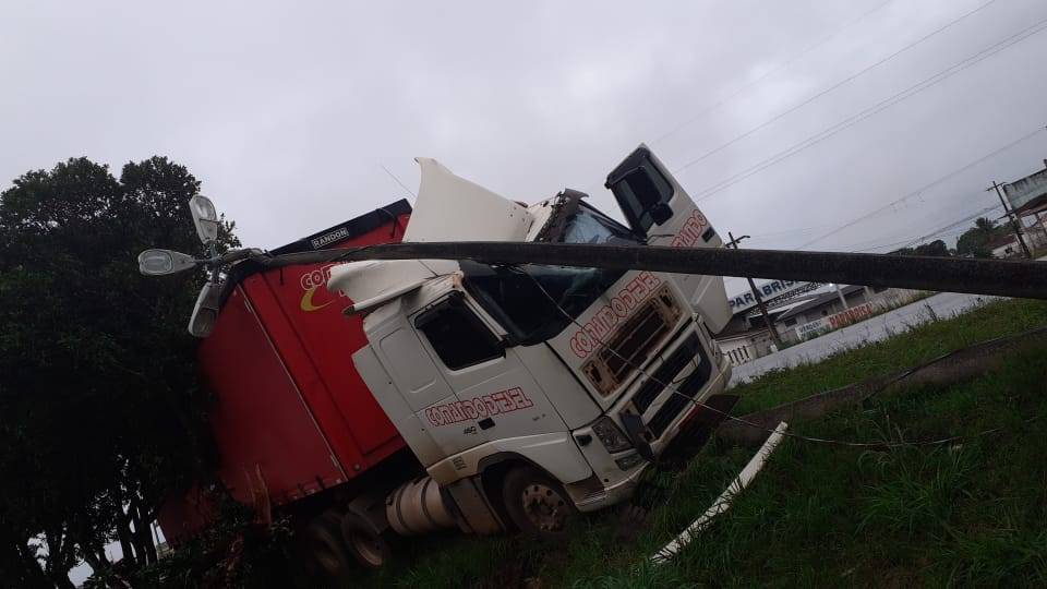 Água na pista faz carreta “rodar” em trecho urbano da BR 364 e atingir poste de energia, que caiu sobre a cabine
