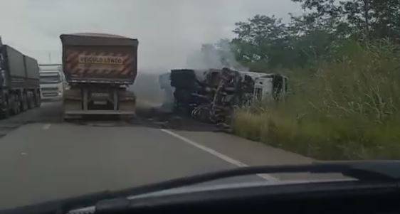 ASSISTA VÍDEO: tentando desviar de buraco na pista, carreta tomba às margens da BR 364 e pega fogo após atingir caminhão-tanque