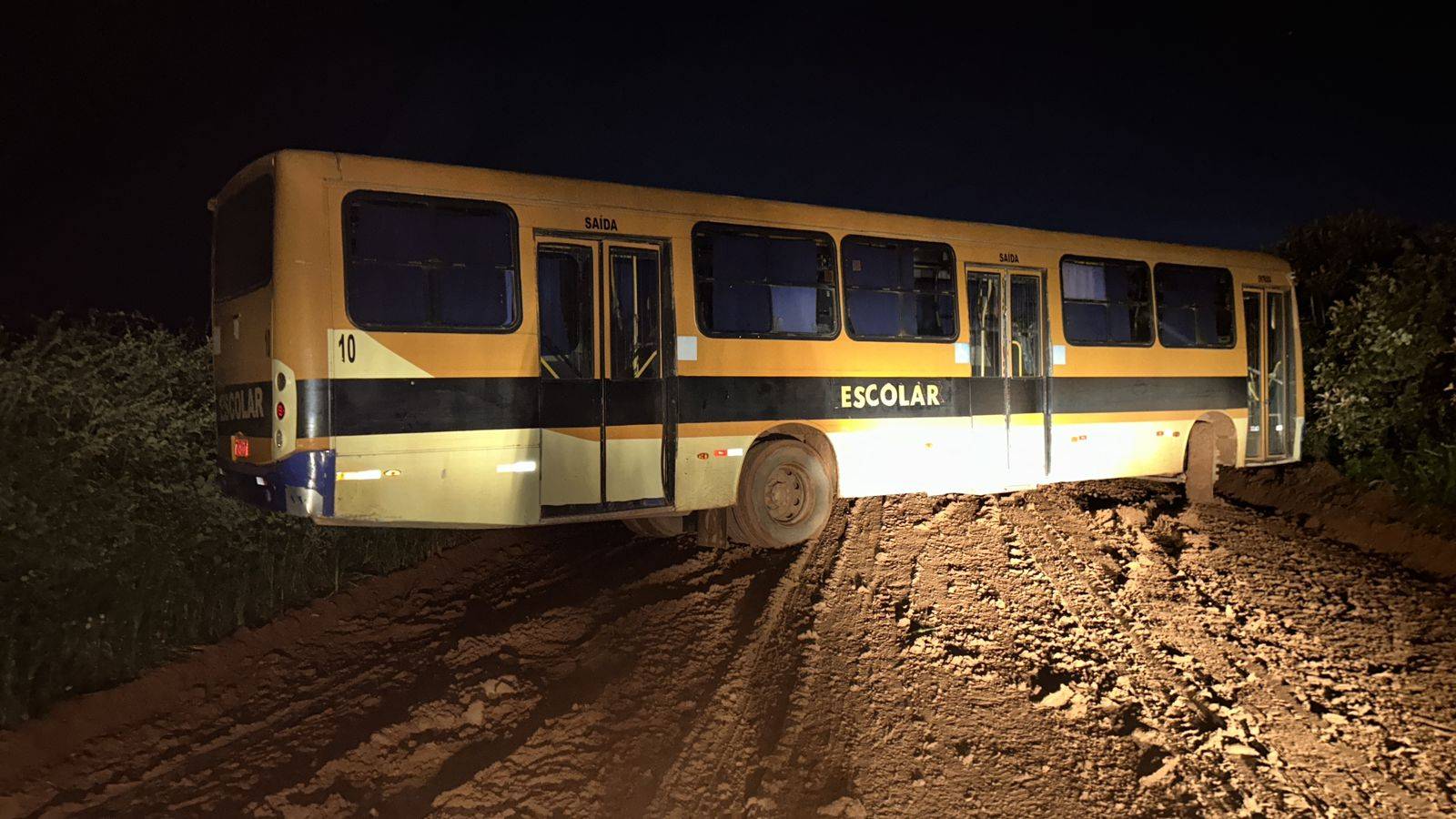 Ônibus escolar atola em lamaçal e deixa estrada interditada, impedindo que moradores cheguem às suas propriedades, em Vilhena