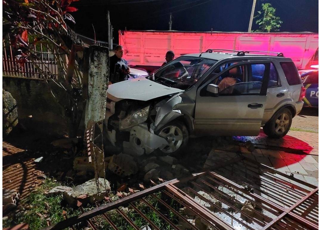 Completamente bêbado, sem CNH e usando carro emprestado, homem destrói muro de casa após mulher grávida evitar o atropelamento