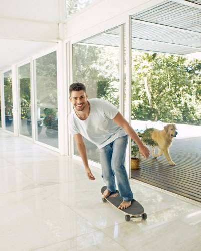 Cauã Reymond abre sua casa e posa com o cachorro para capa de revista